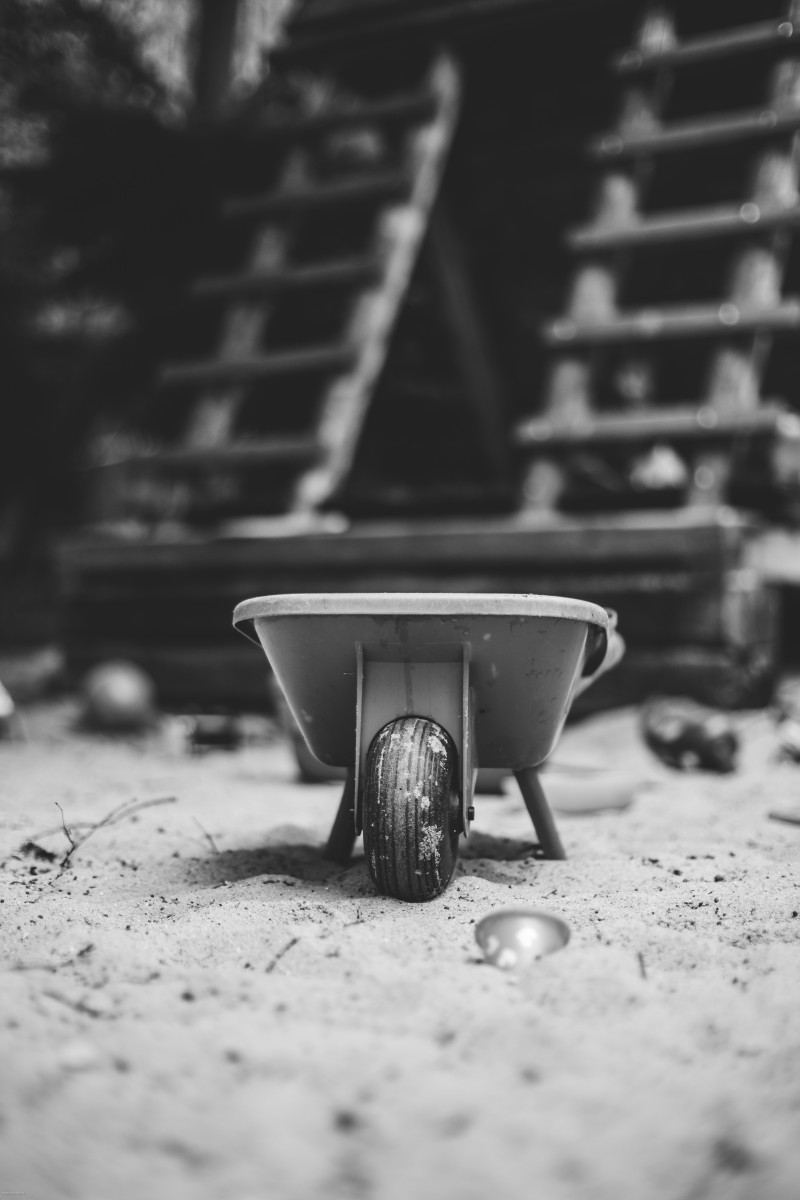 Spielzeug-Schubkarre vor Kletterhäuschen