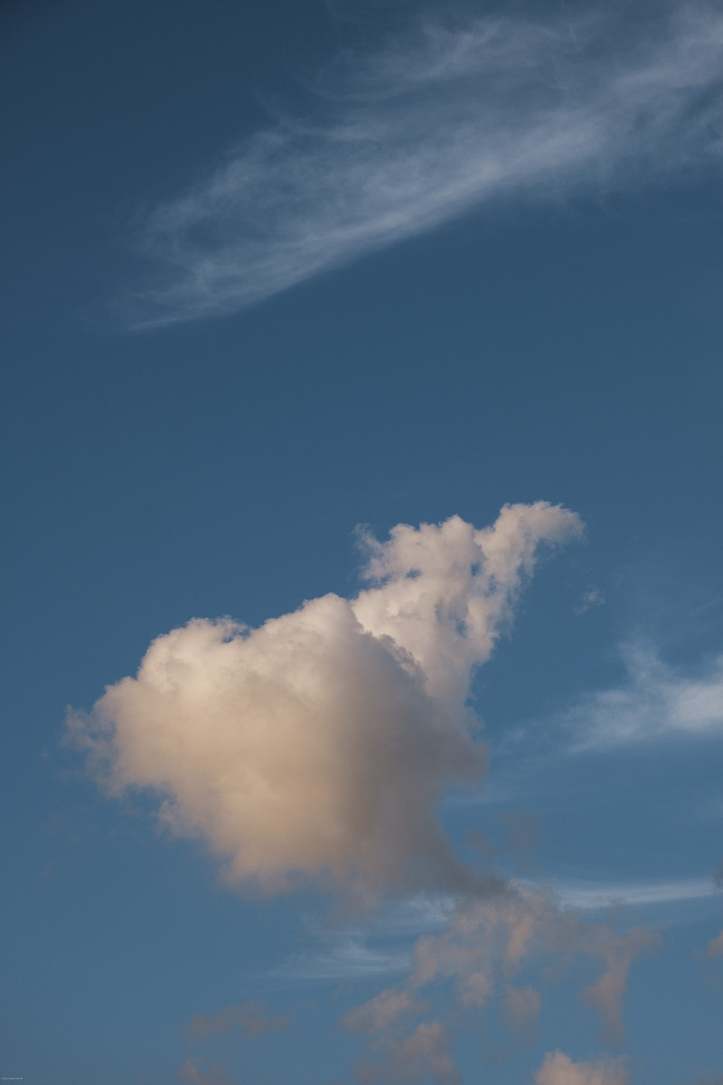 Leicht orange-beleuchtete Wolken am Himmel