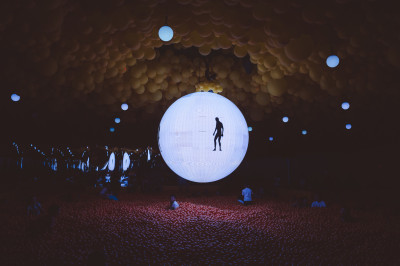 Beleuchteter Ball im Dunkeln über riesigem Bällebad